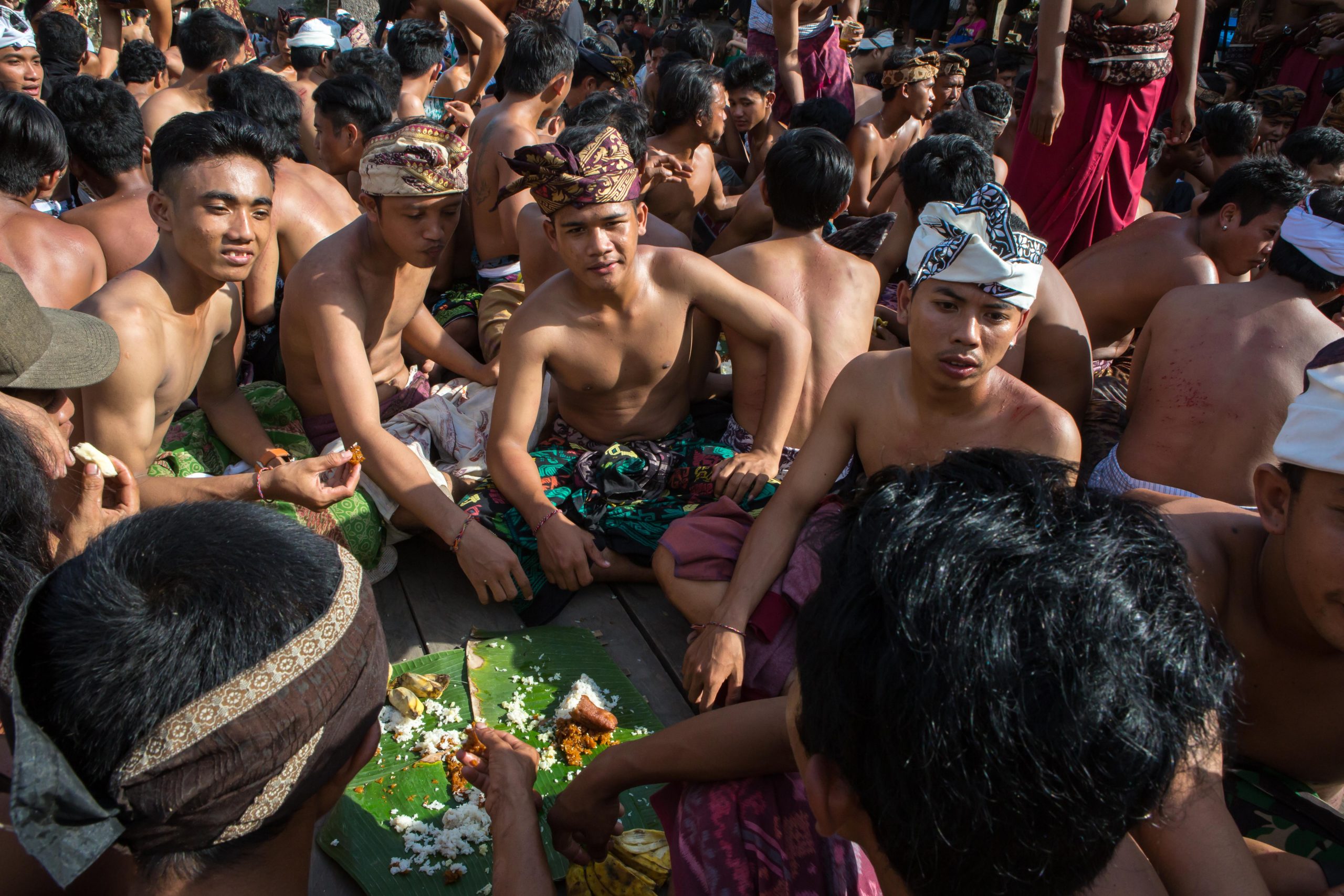 Men sharing communal meal after Mekare-kare ceremony in Tenganan village